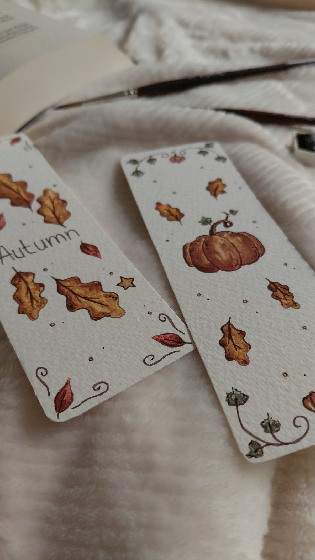 Marque-pages de la collection automne réalisé à la main à l'aquarelle. Deux modèles disponibles, un avec citrouille et feuilles et un avec le mot "Autumn" avec des feuilles